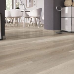 Soft Oak Greige vinyl planks in a bright dining room with white chairs