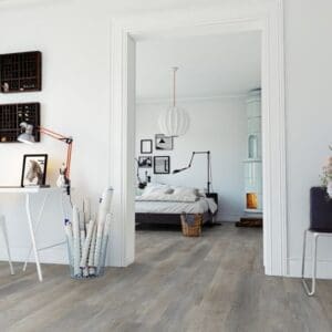 Worn Oak Greige flooring installed in a modern white bedroom and home office