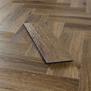 Single plank of Abingdon Tapestry Antique Walnut shown against the installed pattern
