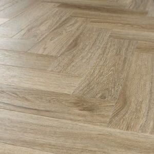 Angled perspective of the Smoky Oak herringbone flooring showing texture and light reflection