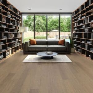 Modern living room interior featuring Autumn Chestnut wood effect flooring with large bookshelves and a dark sofa