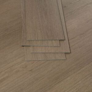 Several loose Autumn Chestnut luxury vinyl planks stacked to show the 3mm thickness and profile