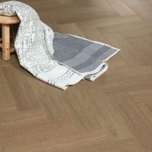 Bridle Oak flooring shown with a small wooden stool and grey textiles to demonstrate its warm earthy tones.