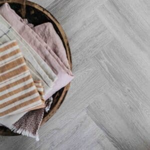 Earl Grey Herringbone flooring installed in a modern kitchen with blue cabinets