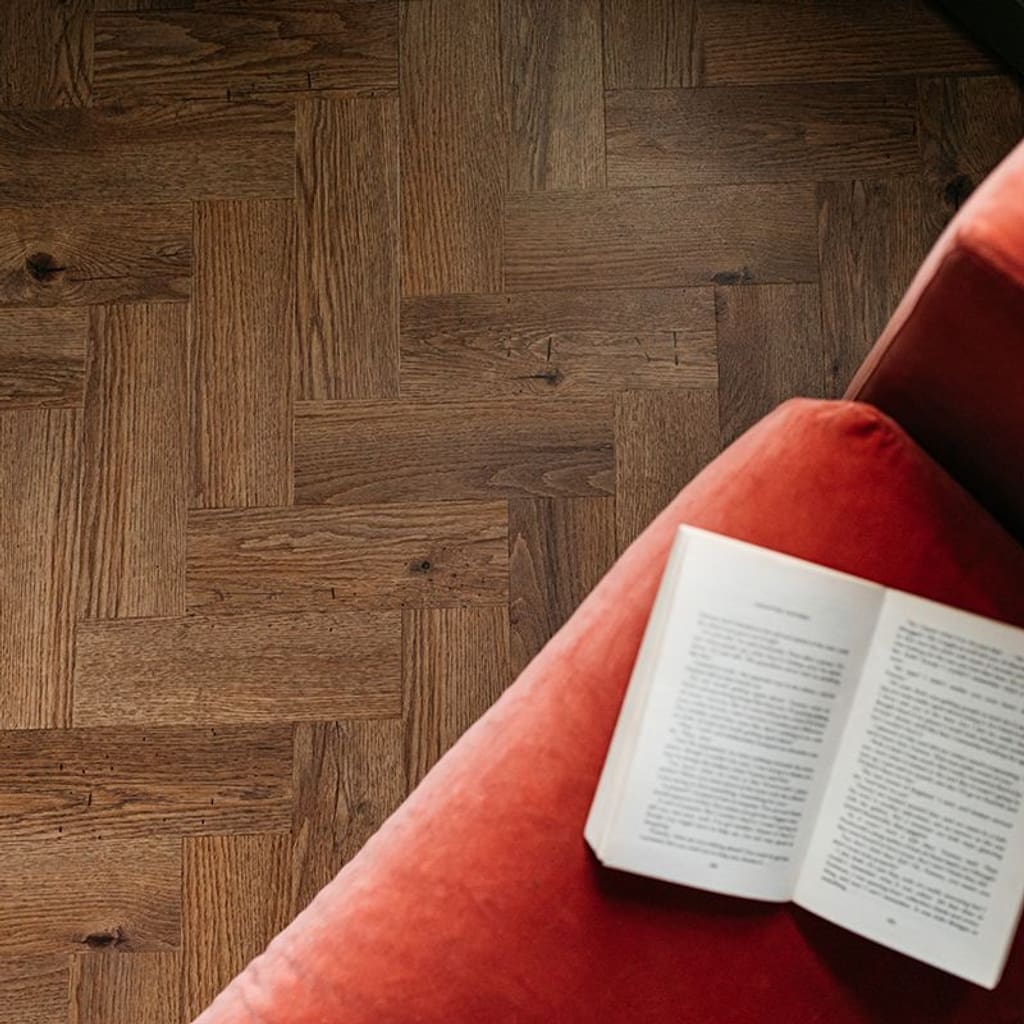 Detailed view of the herringbone installation pattern of fumed oak vinyl tiles