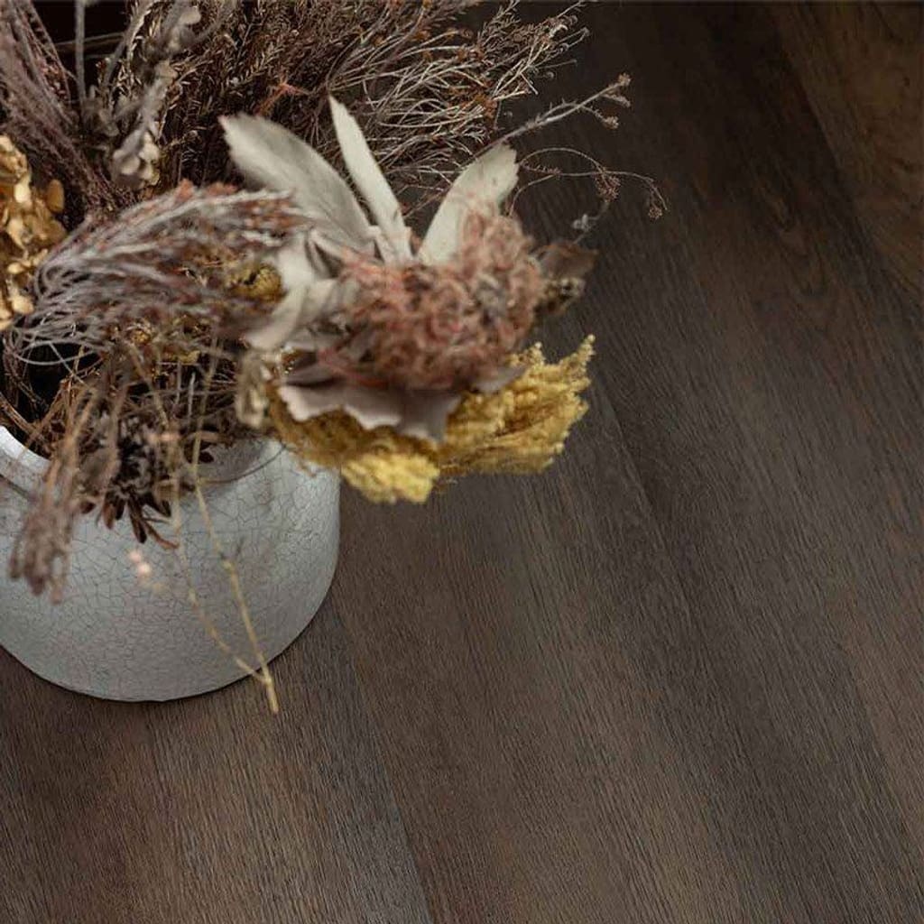 Close up of Harvey Maria Burnt Fig flooring showing wood grain texture under a wooden chair leg
