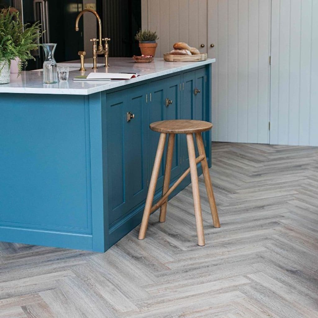 Wide shot of a kitchen featuring Dormouse herringbone luxury vinyl flooring
