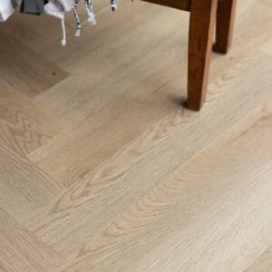 Close up view of the wood grain texture on Farro Herringbone luxury vinyl tiles.
