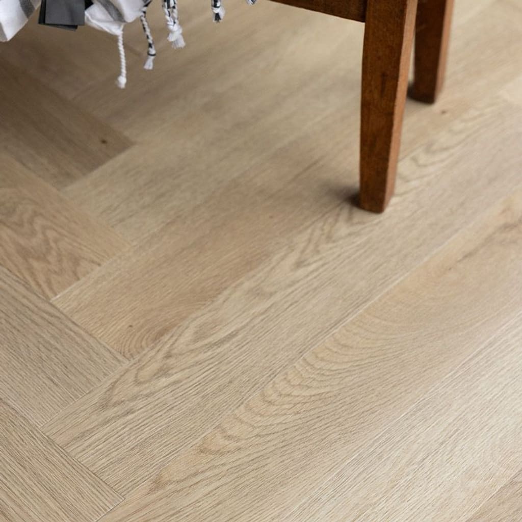 Close up view of the wood grain texture on Farro Herringbone luxury vinyl tiles.