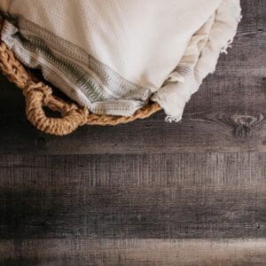Harvey Maria Smokehouse Plank flooring styled with a wicker basket and soft textiles