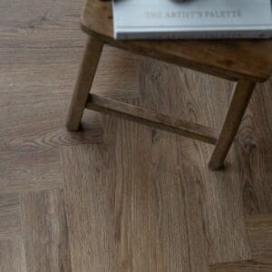 Close up angled view of Harvey Maria Mulberry Herringbone luxury vinyl tiles showing wood grain texture