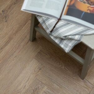 Mulberry Parquet flooring in a living room with a grey plaid armchair and fireplace
