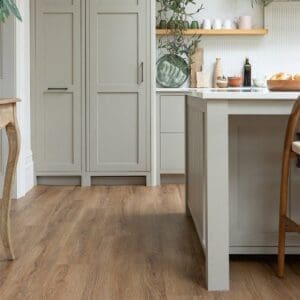 Lifestyle shot of Mulberry Plank flooring in a bright kitchen setting with grey cabinetry