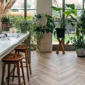 Harvey Maria Old Bramble Chevron flooring installed in a bright modern kitchen with plants