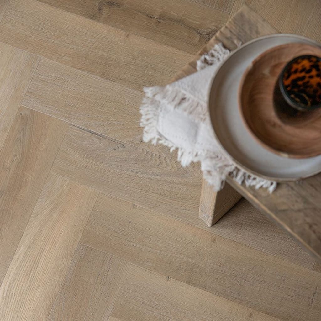 Harvey Maria Rattan Herringbone flooring installed in a modern white kitchen with marble worktops