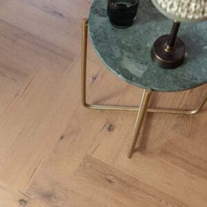 Rowan Herringbone LVT installed in a modern living room with a yellow armchair