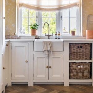 Wide view of Rye Herringbone flooring in a bright kitchen with white units and large windows