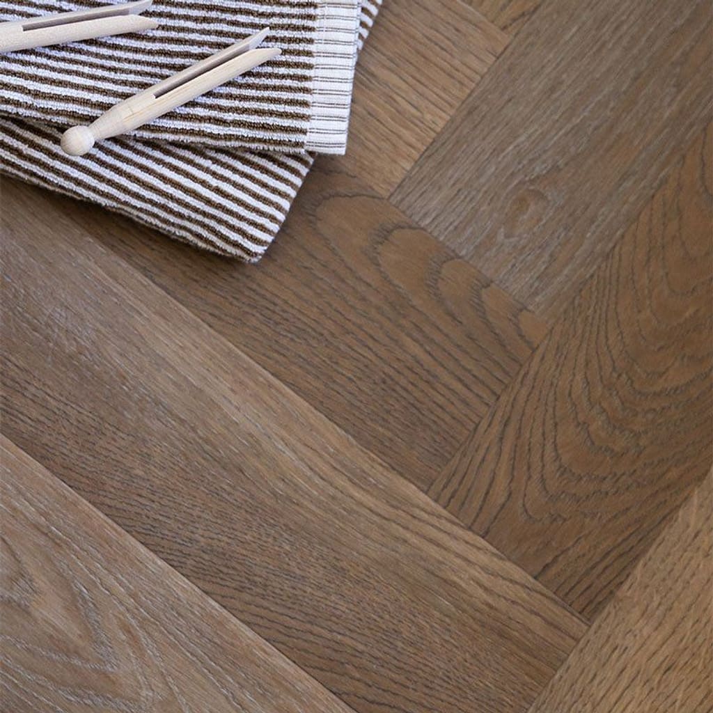 Rye Herringbone wood effect flooring in a utility room with white cabinetry and brass handles