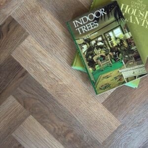 Herringbone layout of Rye Parquet flooring styled with vintage indoor plant books