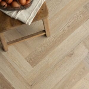 Wide view of a kitchen featuring Wicker Herringbone flooring and natural wood cabinets