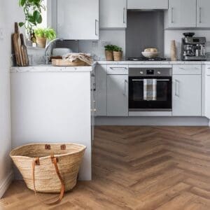 Close up of Wildfox Herringbone flooring against white kitchen cabinetry