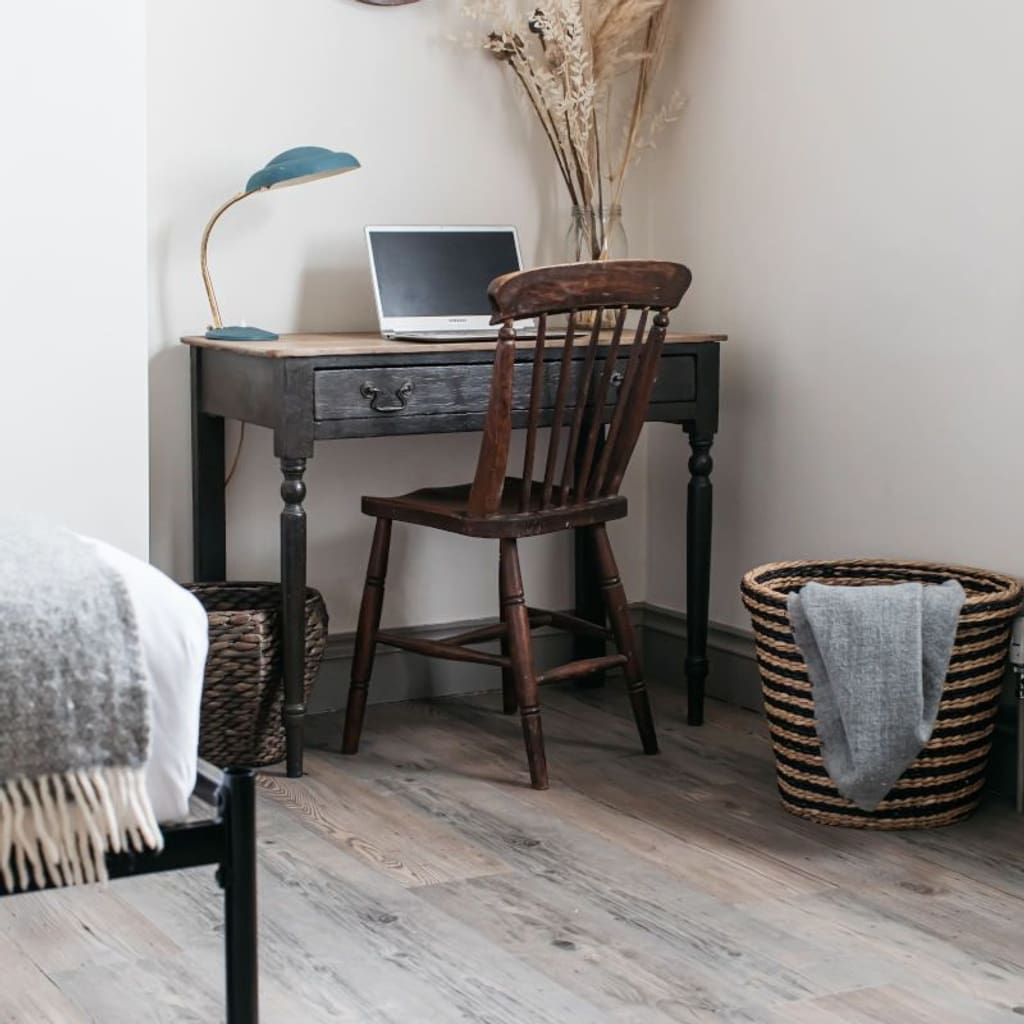 Detailed view of Hickory wood effect flooring planks with a woven basket and grey blanket