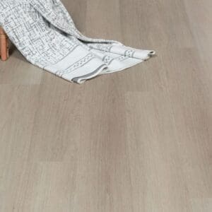 Oregon Ash flooring with a decorative blanket and chair leg in a home setting