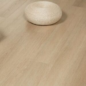 Close up of Swiss Larch LVT planks with a decorative woven footstool