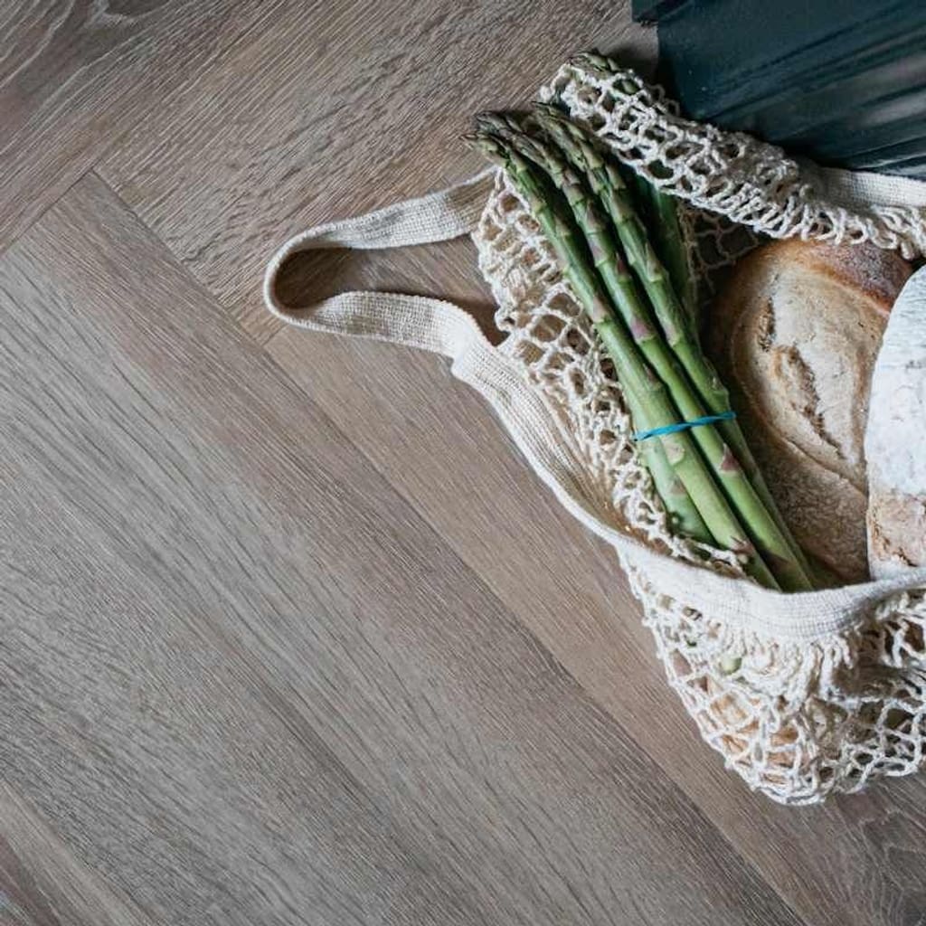 Herringbone pattern flooring leading towards a carpeted staircase in a modern home