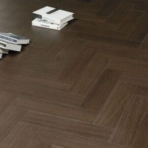 Dark walnut herringbone flooring with a stack of books showing the realistic texture