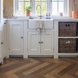 Close up of Rye Herringbone luxury vinyl tile showing wood grain detail and multi-tonal oak shades