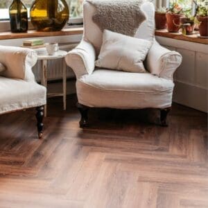 Traditional living room setting featuring wood effect parquet flooring with white armchairs.