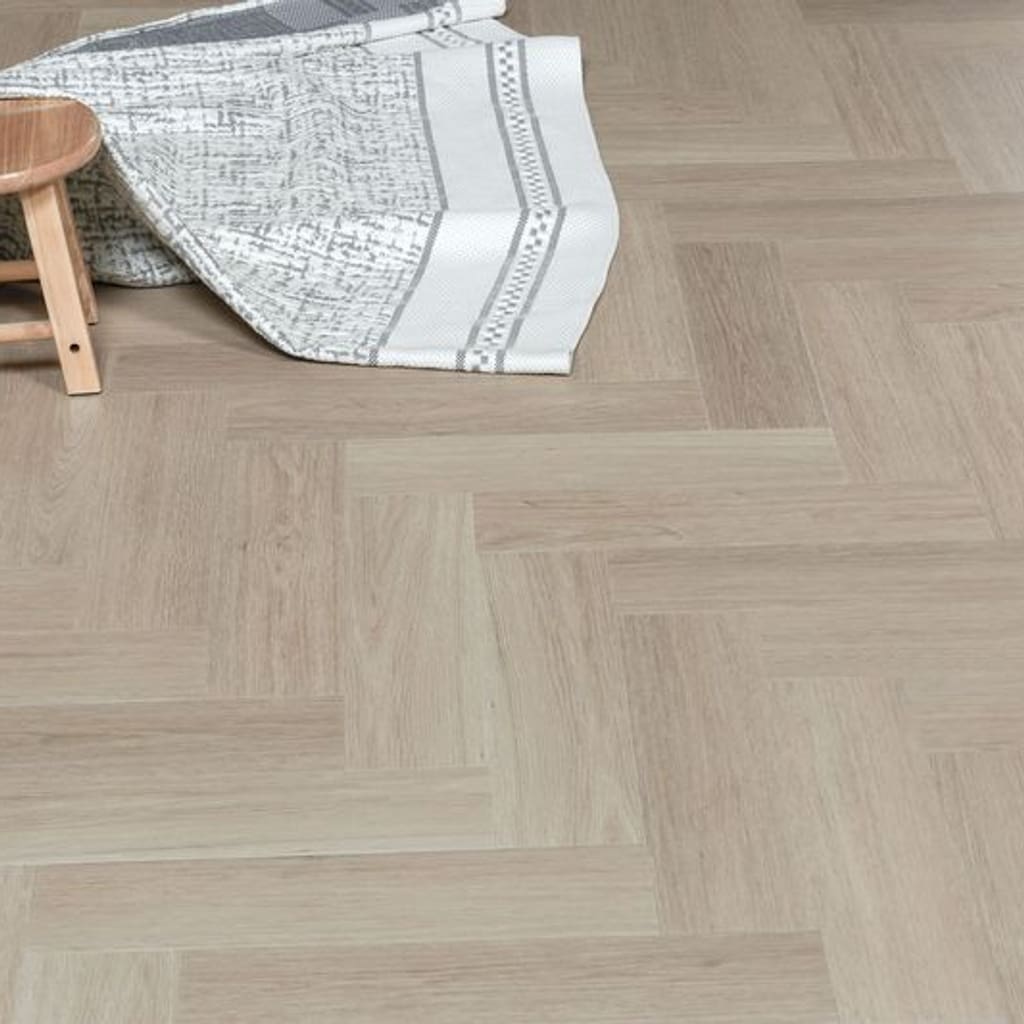 Close up of Vermont Ash flooring with a small wooden stool and a textured rug.
