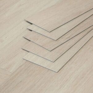A stack of individual Vermont Ash luxury vinyl planks showing the thickness and profile.